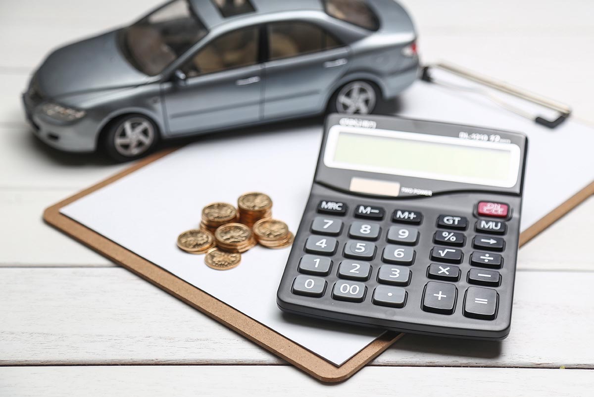 car model,calculator and coins on white table